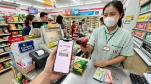 Кассир 7-Eleven сканирует штрихкод бронирования поезда D-Ticket на экране смартфона туриста