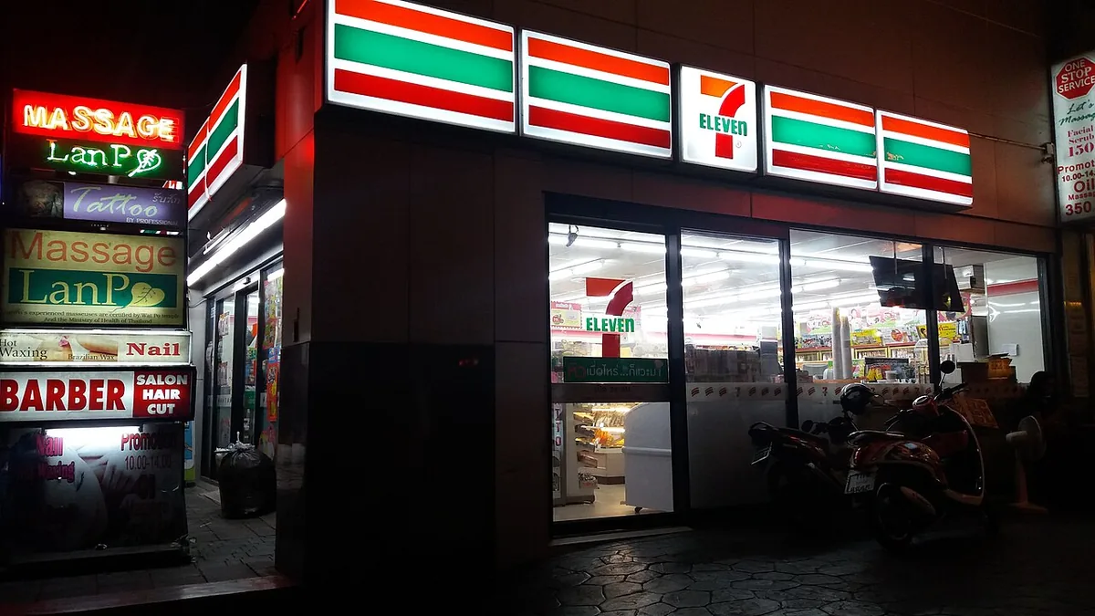 Магазин 7-Eleven вечером на улице Бангкока с яркой вывеской